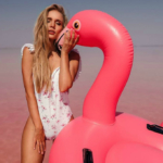 Sexy Model in a white swimsuit with a pink flamingo